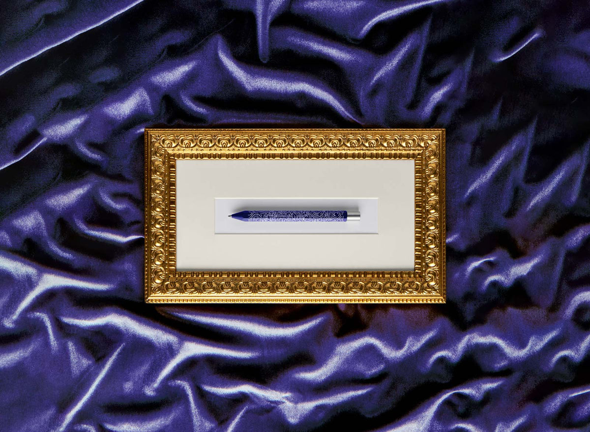 Gold frame with Starry Night Squire Hex pen on a purple fabric background